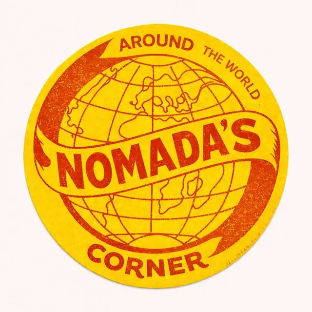 Retro yellow circular travel badge — "NOMADA'S" globe sticker