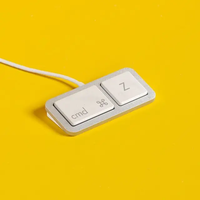 Cmd + Z two-key desktop accessory on yellow backdrop
