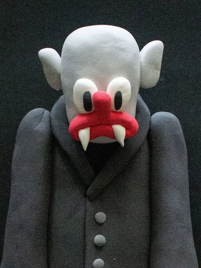 Felt vampire plush in dark grey coat — soft sculpture toy
