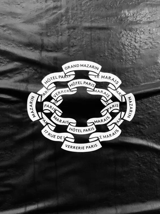 White ribbon-chain Paris logo printed on black wrinkled fabric