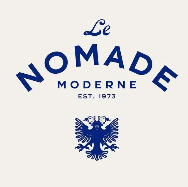 Le Nomade Moderne — navy crest logo with arched wordmark
