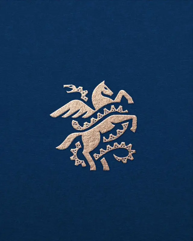 Rose‑gold foil Pegasus emblem on navy linen paper