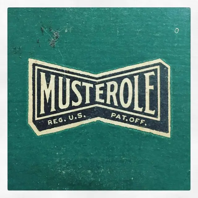 Vintage 'MUSTEROLE' bow-tie label on teal textured paper