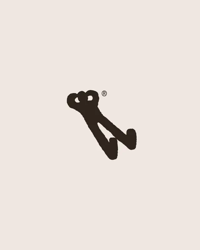Hand-drawn monogram logo (dark brush mark with ®) on cream background