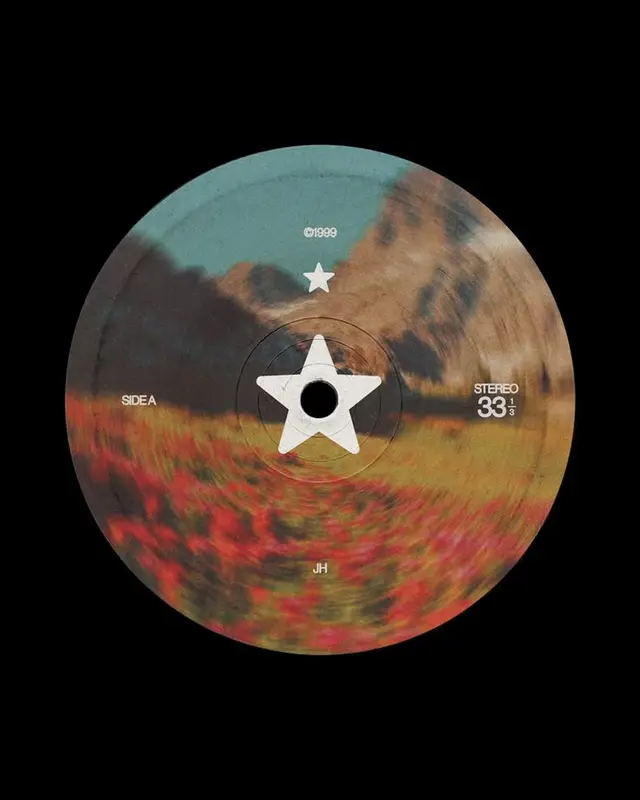 Vinyl label with white star over blurred poppy field and mountains (©1999, Side A, Stereo