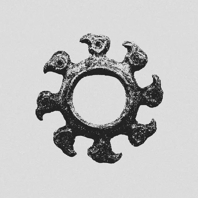 Eight-lobed cast-metal ring with bird-head motifs — monochrome photo
