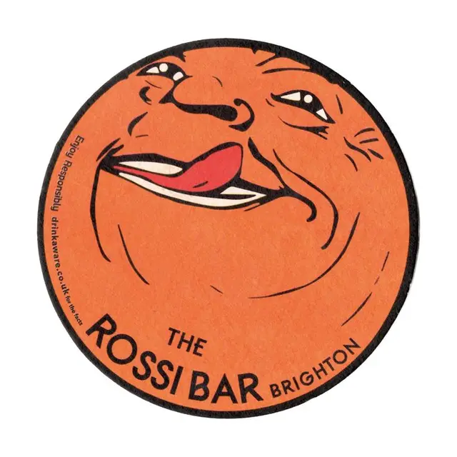 The Rossi Bar circular coaster — orange caricature face (Brighton)