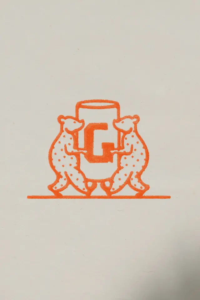 Two Bears Holding a G-Stamped Cylinder — Orange Rubber-Stamp Emblem