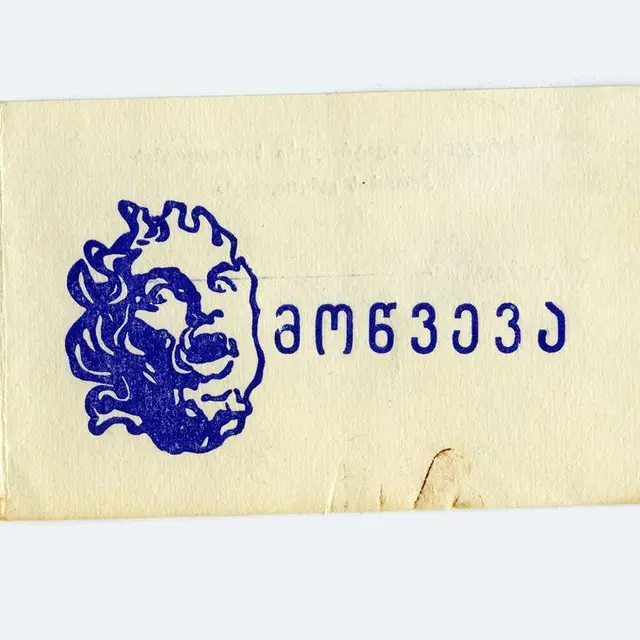Blue ink stamp of classical mask with Georgian lettering on aged paper