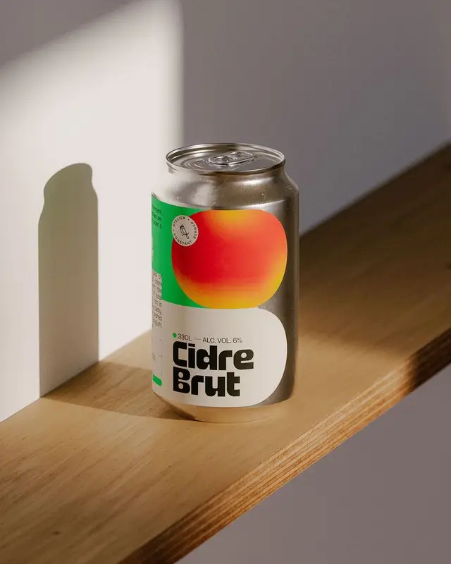 Aluminum can of 'Cidre Brut' with gradient apple label on wooden shelf