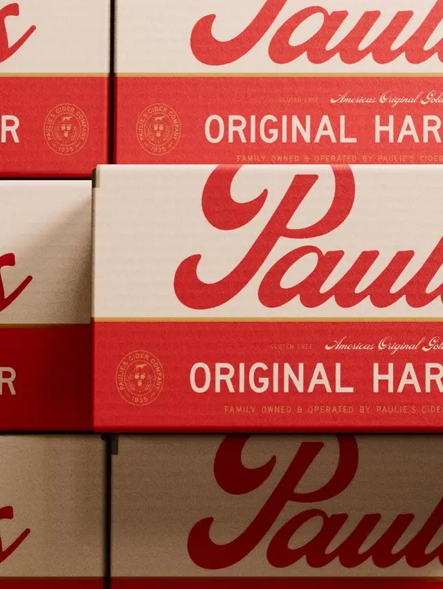 Stacked red-and-cream cider boxes with large script logo
