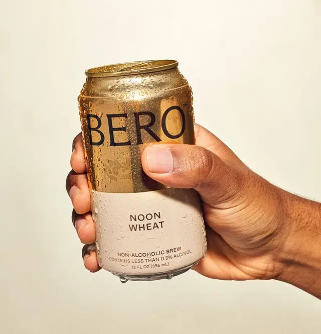 Noon Wheat non-alcoholic brew can held in hand