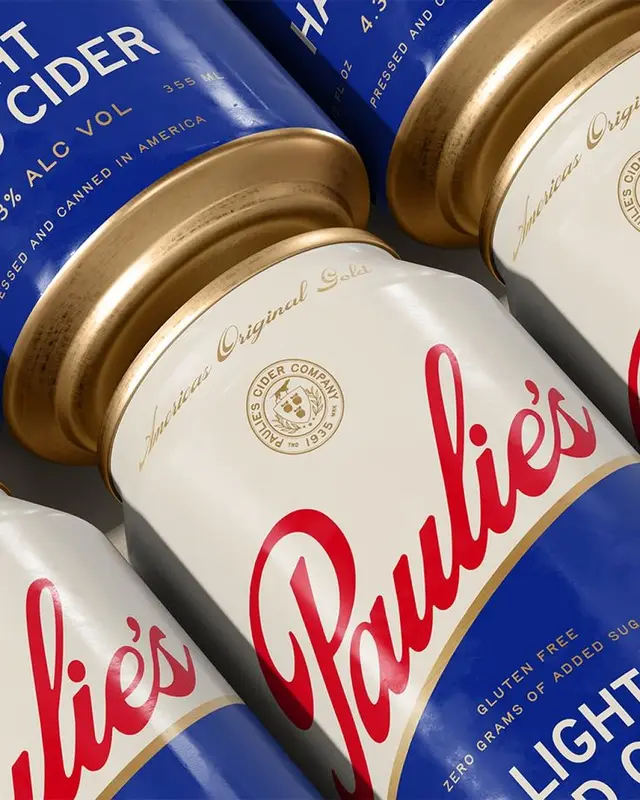 Close-up of Paulie's light cider cans with metallic gold rims