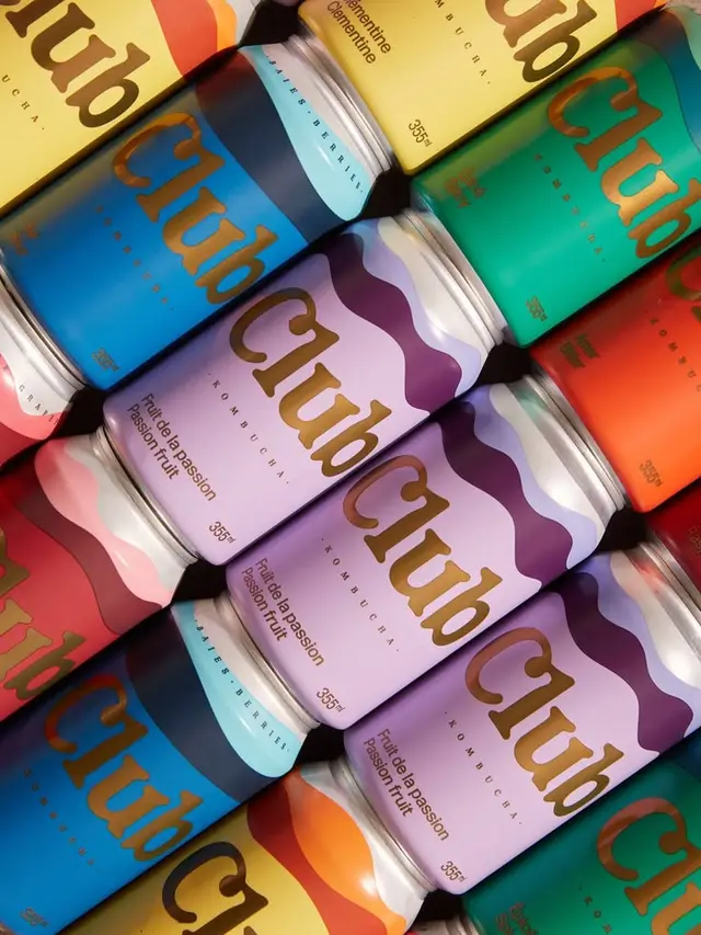 Club kombucha — colorful wave-pattern 355 ml cans, flat-lay