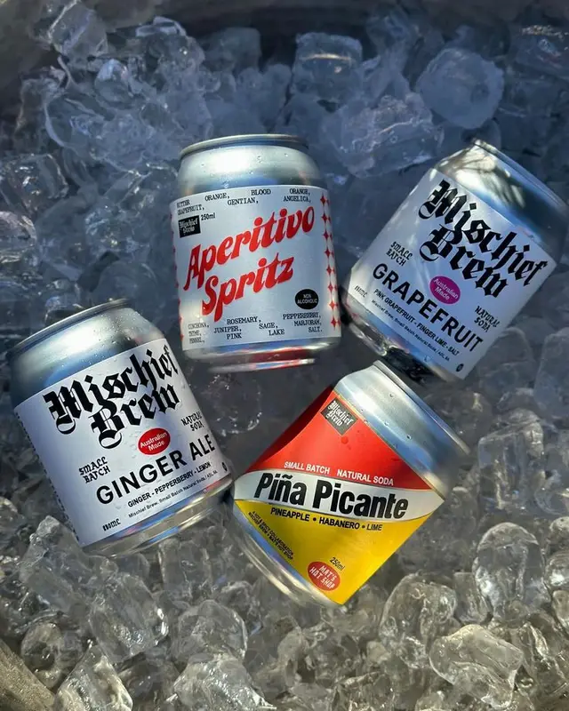 Craft soda cans on crushed ice — Mischief Brew, Aperitivo Spritz, Piña Picante