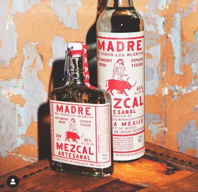 MADRE Mezcal Artesanal bottles — red-on-cream label still life