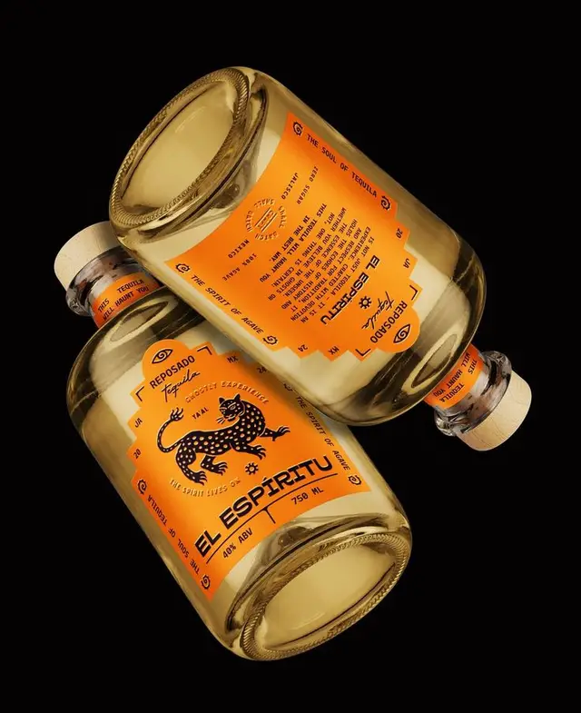 El Espiritu Reposado tequila — orange-labeled glass bottles on black background