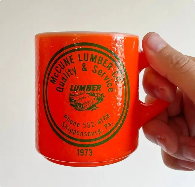 Vintage 1973 McCune Lumber Co. orange promotional mug (Shippensburg, PA)