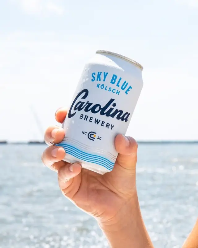 Carolina Brewery — Sky Blue Kölsch can held over the ocean