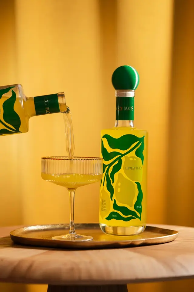 Lemon liqueur bottle with green leaf label and coupe glass