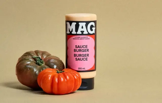 MAG burger sauce 350 mL bottle with two heirloom tomatoes on beige background