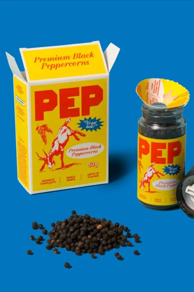 PEP premium black peppercorns — yellow packaging and glass jar on blue background