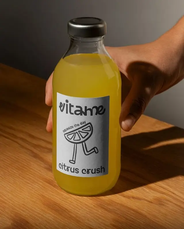 Vitame Citrus Crush — glass bottle with silver label held over wooden table