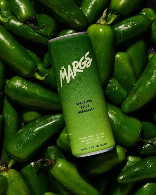 Sip MARGS canned Sparkling Spicy Margarita on pile of jalapeños
