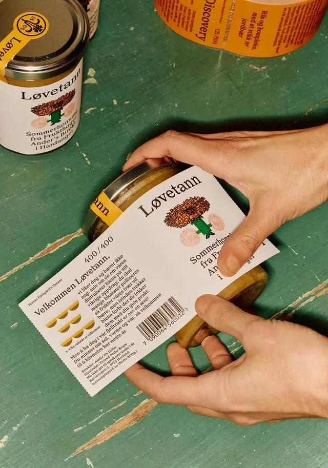 Løvetann Sommerhonning jar with paper label being applied