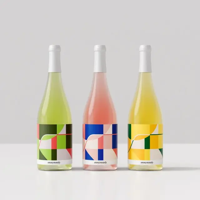 Three wine bottles with bold geometric color-block labels — studio mockup