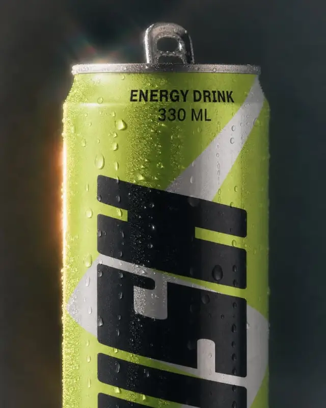 Lime-green 330 ml energy drink can with condensation — studio product shot