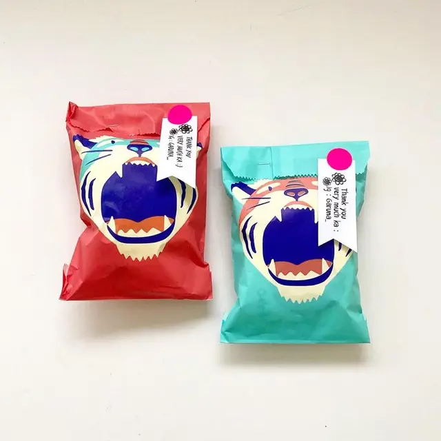 Roaring tiger snack pouches — red and turquoise packaging with thank-you tags