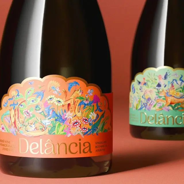 Delância bottle with scalloped botanical label on coral background