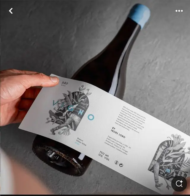 Dark wine bottle with white wraparound label and light-blue wax capsule