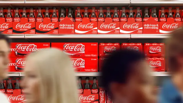 Coca‑Cola retail shelf display with red cans and glass bottles