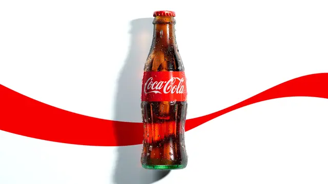 Coca‑Cola contour glass bottle with red ribbon packaging shot