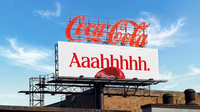 Coca-Cola rooftop neon sign above billboard reading "Aaahhhhh."