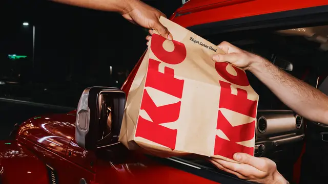 KFC kraft takeout bag handed through red car window at night