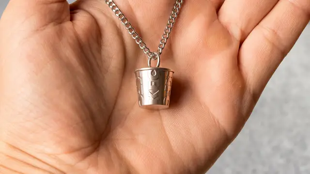 KFC miniature bucket pendant on silver chain held in hand