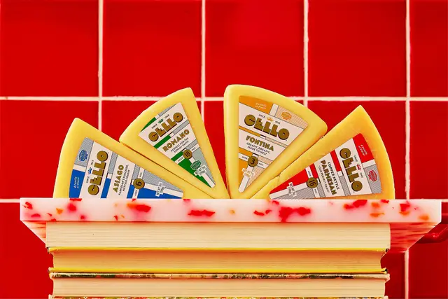 CELLO cheese wedge packaging displayed on red tile with terrazzo shelf