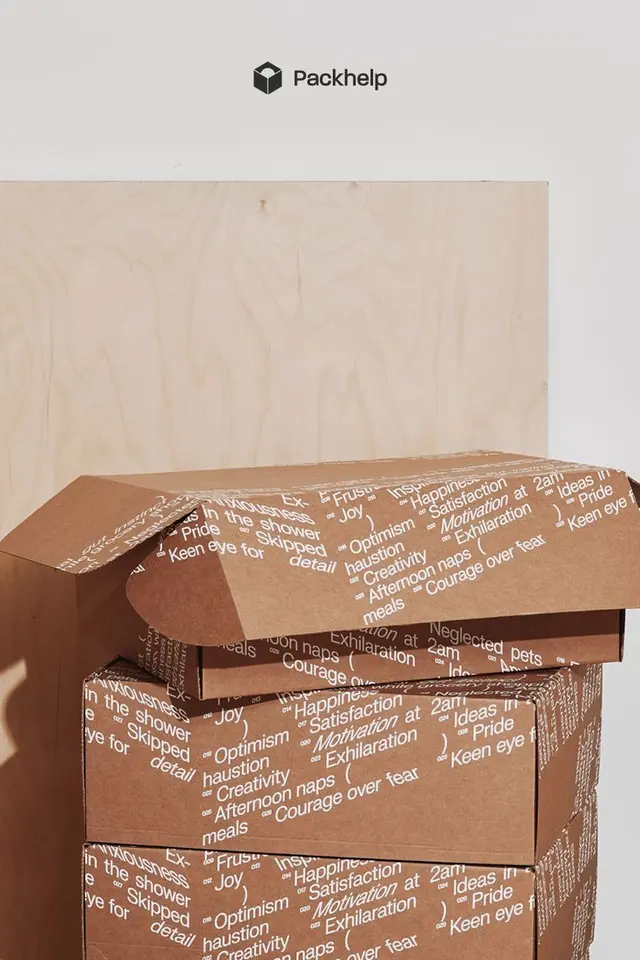 Stacked kraft shipping boxes with all-over white typography — Packhelp