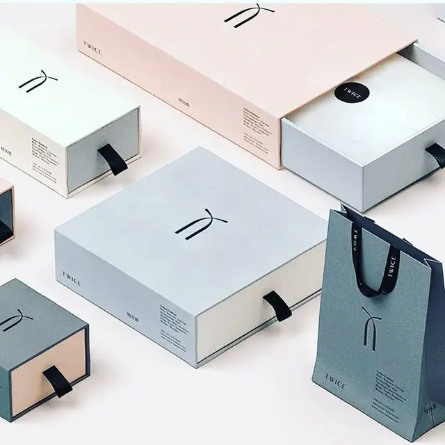 Pastel sliding-drawer gift boxes and paper bag with 'TWICE' logo
