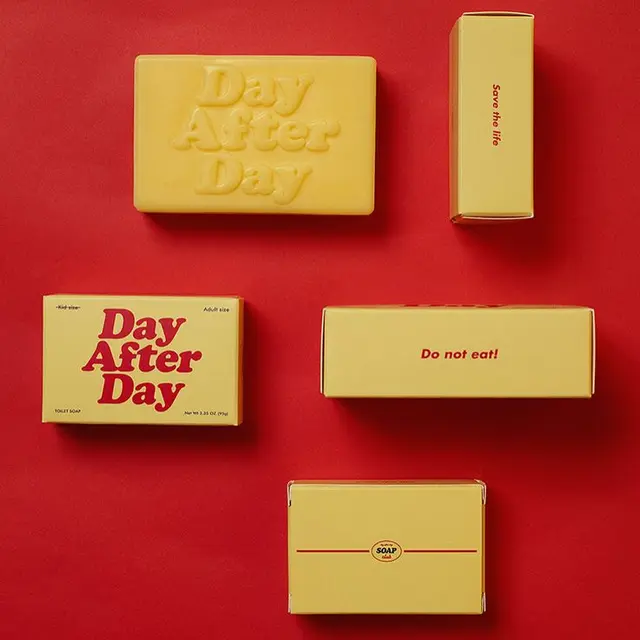 Day After Day yellow soap packaging flat-lay on red background