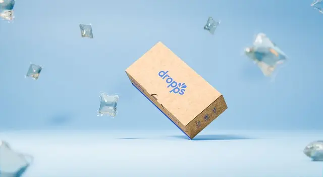 Dropps brand refresh — kraft boxes with blue-green leaf graphics