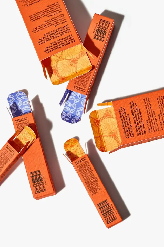 Ami Colé citrus‑orange packaging — bold black foil typography by School House