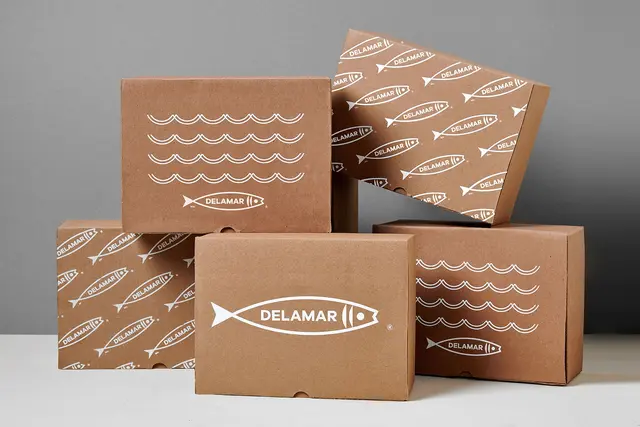 Delamar seafood packaging — kraft boxes with white fish logo (Parámetro Studio)