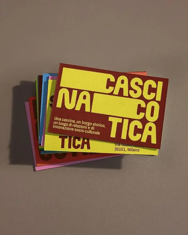 Stack of colorful business cards with bold yellow typography for a Milano sociocultural 'C