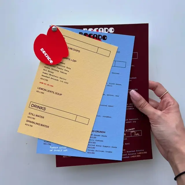 Layered color-block restaurant menus with heart-shaped red tag (Bocado)