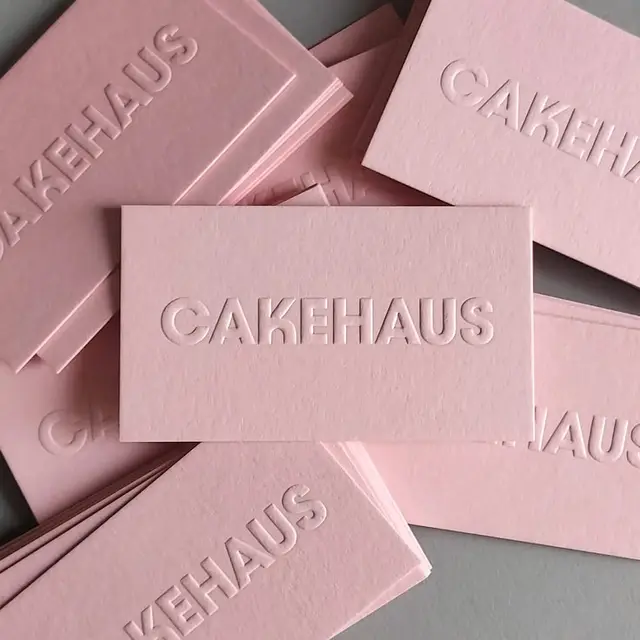 Pink blind-embossed "CAKEHAUS" business cards, stacked