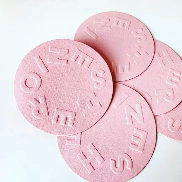Pastel pink embossed round felt coasters